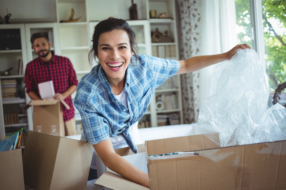 Happy couple unpacking cartons in their new house-2